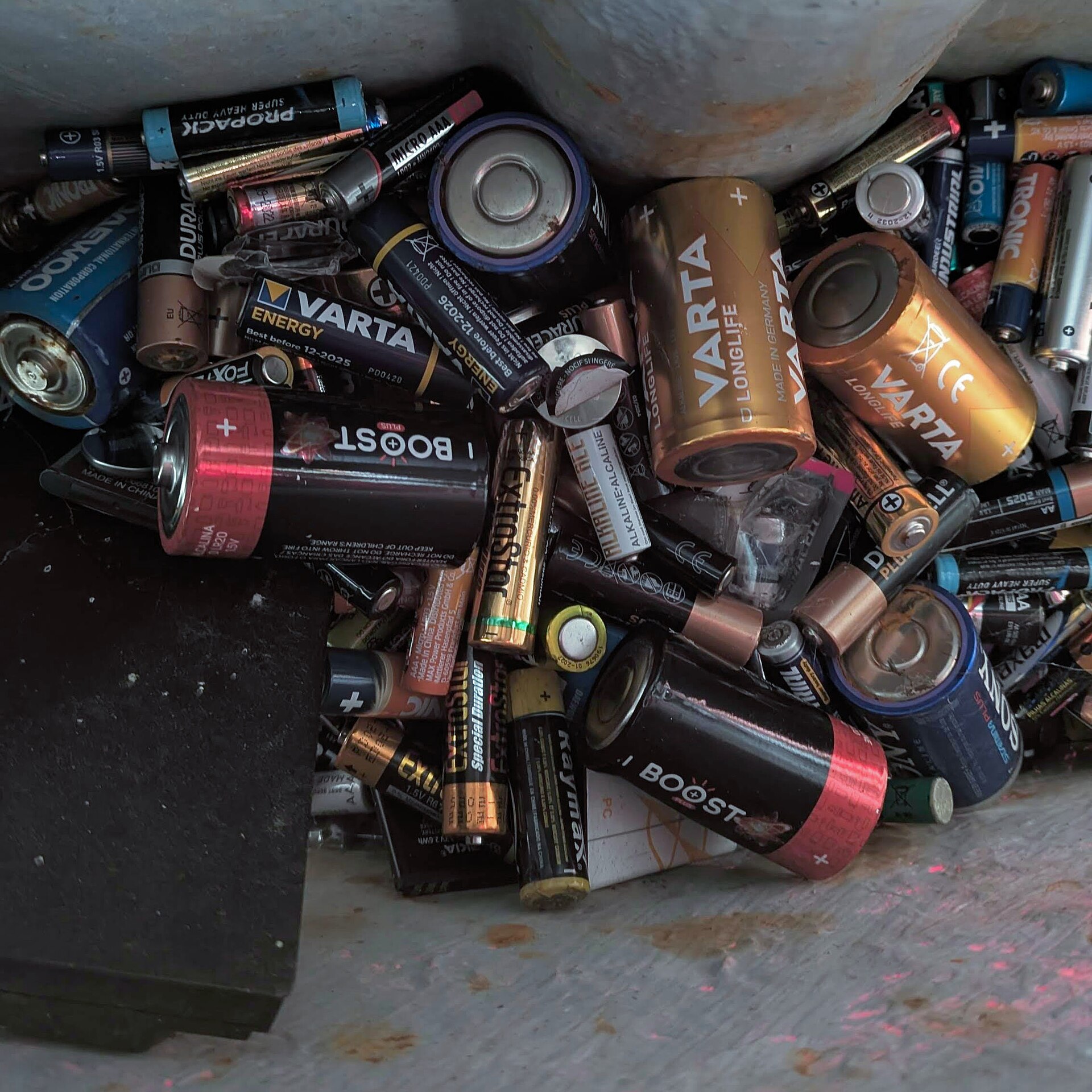 A large pile of used household batteries collected for recycling