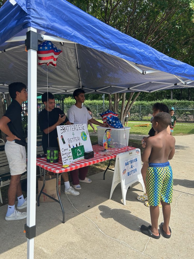 Batteries4Better volunteers talking with families at the booth